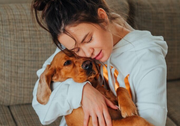 A woman hugging her pet dog out of love